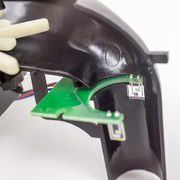 Electronic control board inside the Valken V-MAX Plus loader featuring microchip components that power the motor, manage the paddle feed system, and control LED battery indicators.