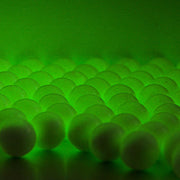 Glowing Valken Accelerate ProMatch 0.20g Airsoft Tracer BBs activated by a tracer unit